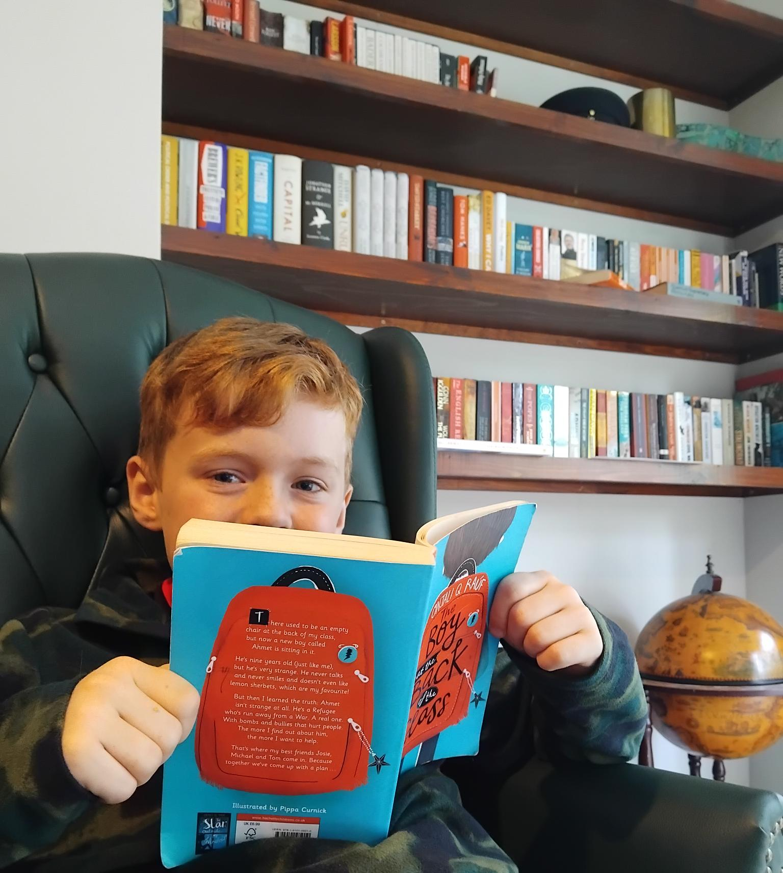 Me reading Boy at the Back of the Class in my father's study.